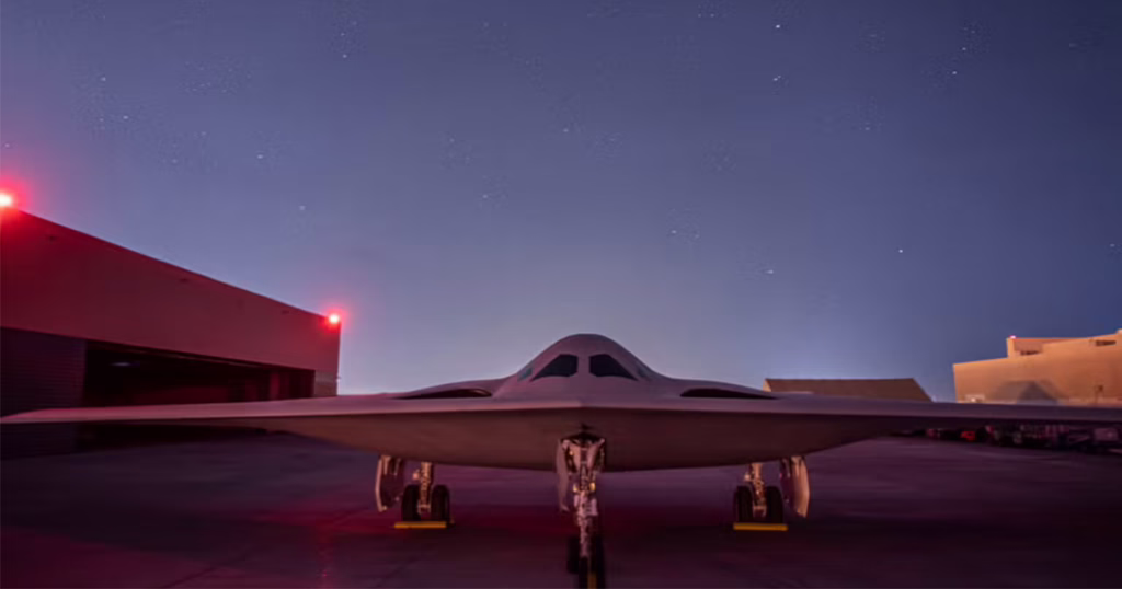 B-21 Raider stealth bomber positioned on a runway at night under low-light conditions